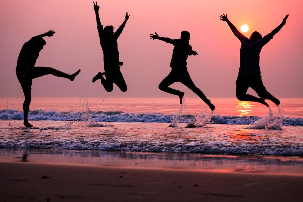 People jumping in air by ocean