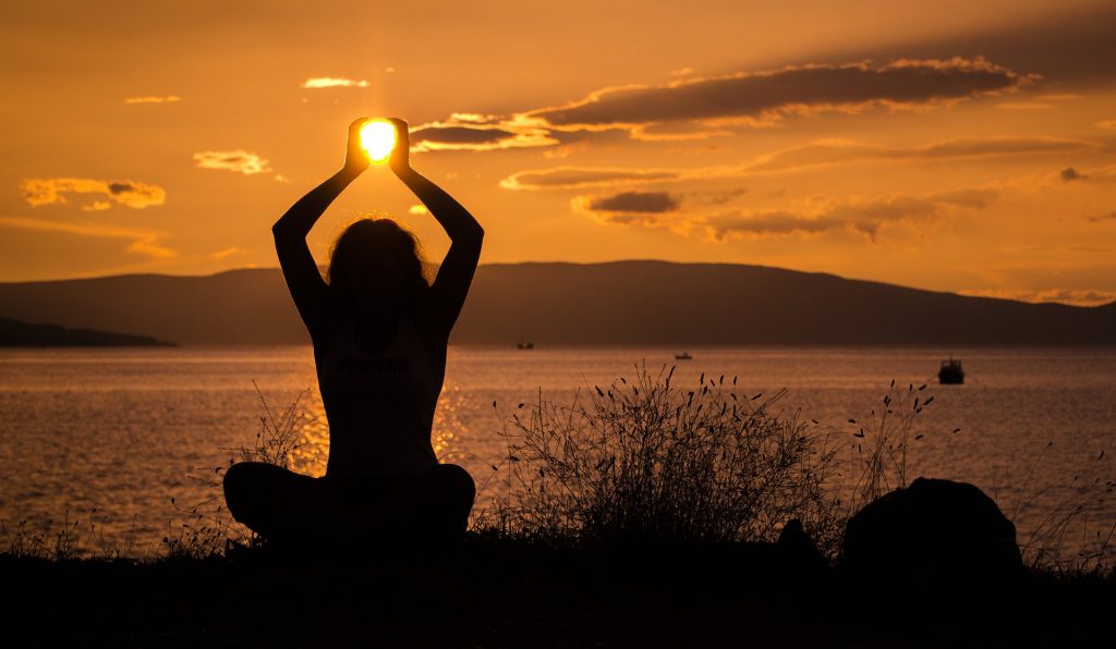 a person doing yoga at sunset