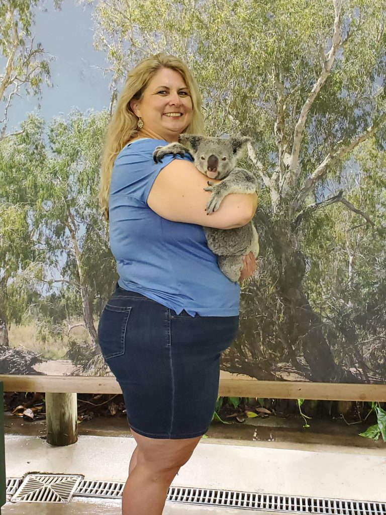 a women holding a koala